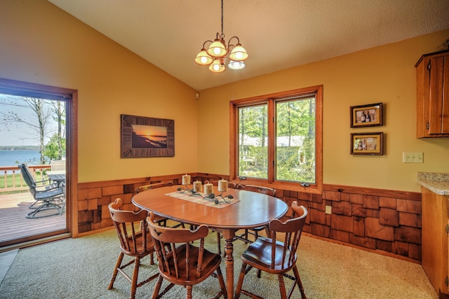 27166 Hersant Rd, Meenon Twp, WI 54893 - dining room featuring wainscoting, vaulted ceiling, light colored carpet, a chandelier, and wood walls