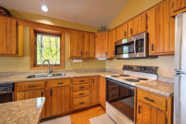 27166 Hersant Rd, Meenon Twp, WI 54893 - kitchen featuring white appliances, a sink, light countertops, vaulted ceiling, and brown cabinets
