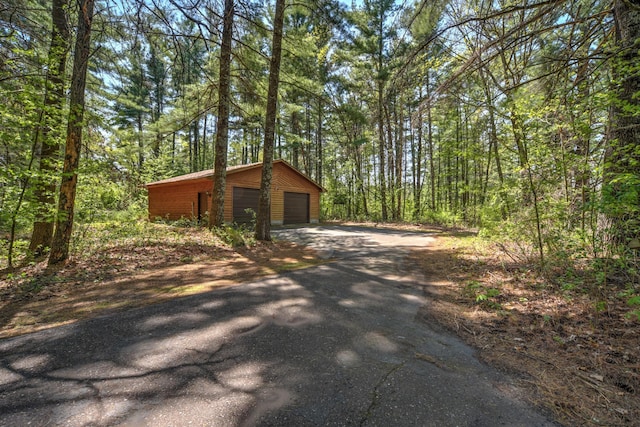 27166 Hersant Rd, Meenon Twp, WI 54893 - view of side of home featuring a garage, an outdoor structure, and a wooded view