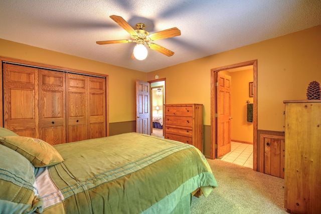 27166 Hersant Rd, Meenon Twp, WI 54893 - carpeted bedroom with a wainscoted wall, a closet, ensuite bathroom, ceiling fan, and tile patterned floors