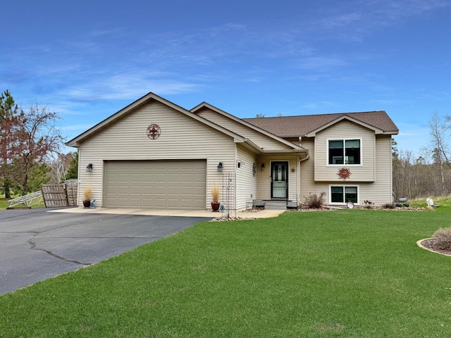 split level home with asphalt driveway, an attached garage, and a front lawn