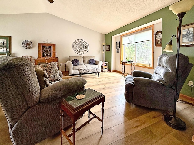 living area with vaulted ceiling, light wood-type flooring, and ceiling fan