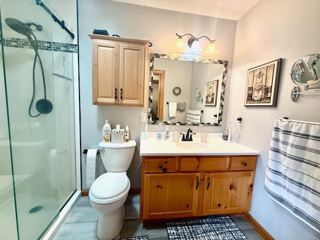 bathroom with a stall shower, toilet, vanity, and baseboards