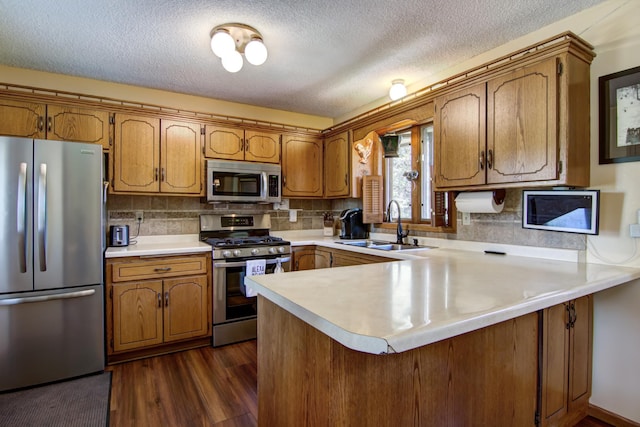 14177 205th St N, Scandia, MN 55073 - kitchen with stainless steel appliances, a peninsula, brown cabinetry, light countertops, and a textured ceiling