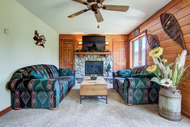 14177 205th St N, Scandia, MN 55073 - carpeted living room featuring wood walls, a textured ceiling, a ceiling fan, and a fireplace
