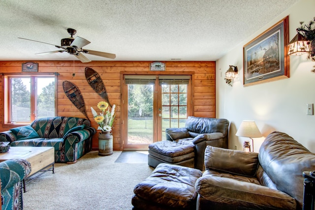 14177 205th St N, Scandia, MN 55073 - carpeted living area featuring healthy amount of natural light, a textured ceiling, wood walls, ceiling fan, and french doors