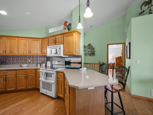 2200 142nd Ln NW, Andover, MN 55304 - kitchen featuring white appliances, lofted ceiling, light wood-style floors, a breakfast bar, and light countertops
