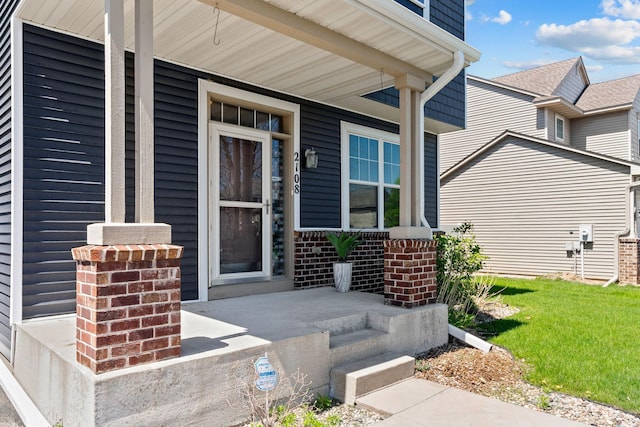 entrance to property with covered porch and brick siding
