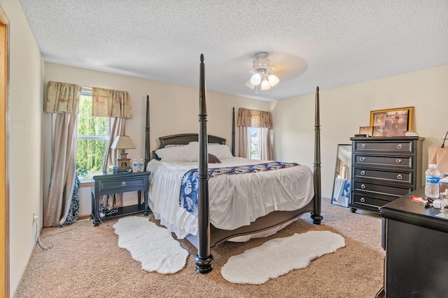 bedroom featuring carpet, multiple windows, a textured ceiling, and a ceiling fan