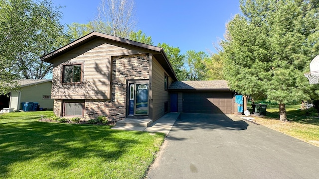 split level home with brick siding, a front yard, and driveway