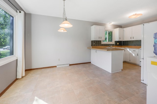 805 3rd Ave N, Sartell, MN 56377 - kitchen with backsplash, a peninsula, white cabinetry, pendant lighting, and a baseboard heating unit