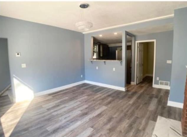 unfurnished living room with baseboards and wood finished floors