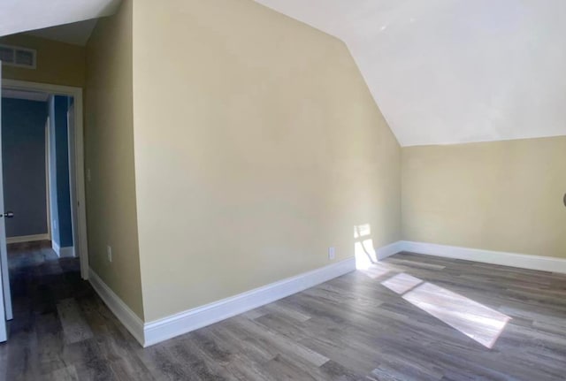 additional living space featuring vaulted ceiling, wood finished floors, and baseboards