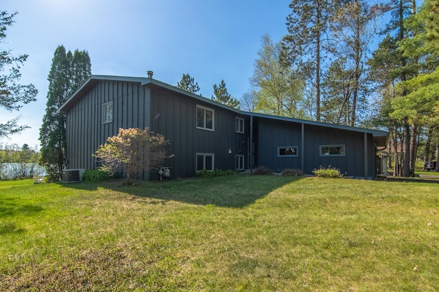10415 Sorenson Dr, Hayward, WI 54843 - back of house with board and batten siding, a yard, and central air condition unit