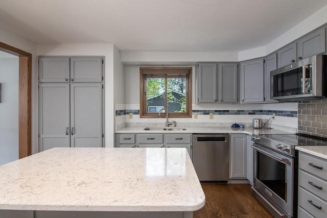 10415 Sorenson Dr, Hayward, WI 54843 - kitchen with appliances with stainless steel finishes, a sink, gray cabinetry, dark wood finished floors, and decorative backsplash