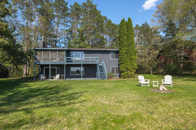10415 Sorenson Dr, Hayward, WI 54843 - rear view of house with stairs, a sunroom, a wooden deck, a lawn, and a chimney