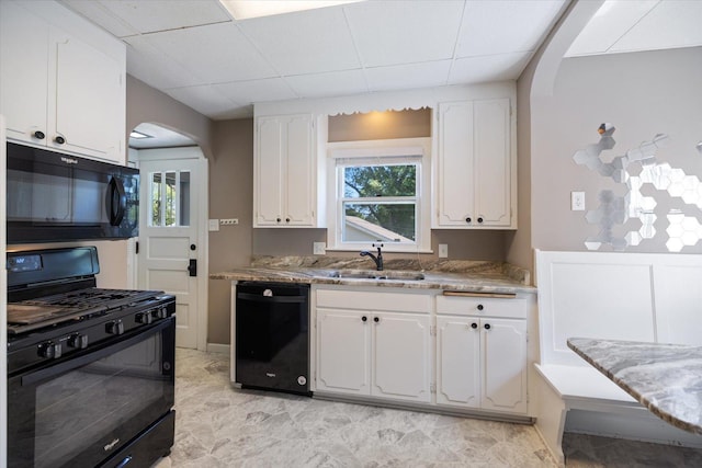 4505 47th Ave S, Minneapolis, MN 55406 - kitchen with black appliances, a sink, arched walkways, white cabinetry, and a paneled ceiling