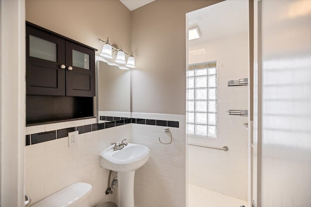 4505 47th Ave S, Minneapolis, MN 55406 - bathroom featuring tile walls, a stall shower, toilet, and a wainscoted wall