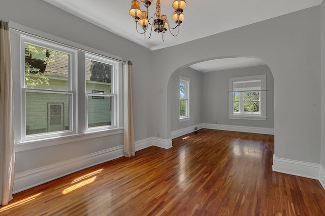 506 Riverside Dr SE, Saint Cloud, MN 56304 - empty room with arched walkways, wood finished floors, a chandelier, and baseboards