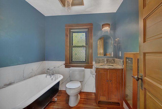 506 Riverside Dr SE, Saint Cloud, MN 56304 - full bath featuring wood finished floors, toilet, a freestanding bath, tile walls, and a wainscoted wall
