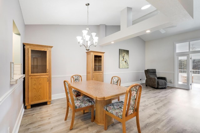dining room with light wood-type flooring, recessed lighting, vaulted ceiling, a chandelier, and baseboards