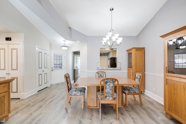 dining space with vaulted ceiling, a chandelier, light wood-style flooring, and baseboards