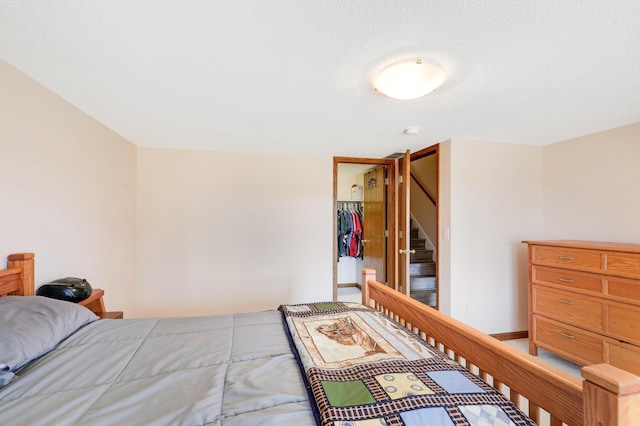 bedroom featuring a walk in closet, a closet, and baseboards