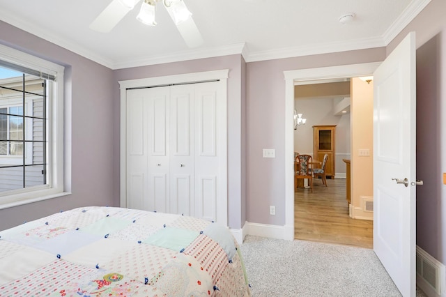 bedroom with light carpet, a closet, ornamental molding, baseboards, and ceiling fan