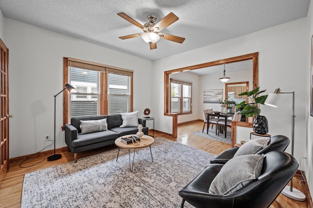 3608 Park Ave Unit 102, Minneapolis, MN 55407 - living room featuring ceiling fan, light wood-style floors, baseboards, and a textured ceiling