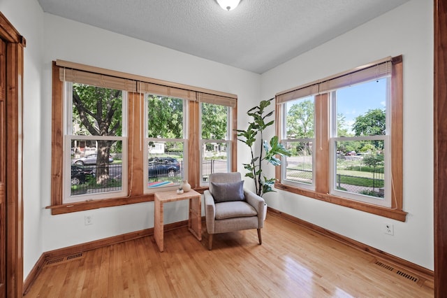 3608 Park Ave Unit 102, Minneapolis, MN 55407 - sitting room featuring baseboards, light wood finished floors, healthy amount of natural light, and a textured ceiling