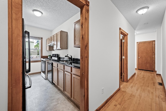 3608 Park Ave Unit 102, Minneapolis, MN 55407 - hallway with a textured ceiling, baseboards, and a sink