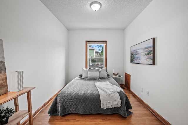3608 Park Ave Unit 102, Minneapolis, MN 55407 - bedroom with a textured ceiling, wood finished floors, and baseboards