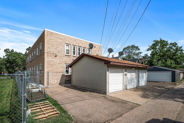 3608 Park Ave Unit 102, Minneapolis, MN 55407 - back of property with a gate, a garage, an outbuilding, and brick siding
