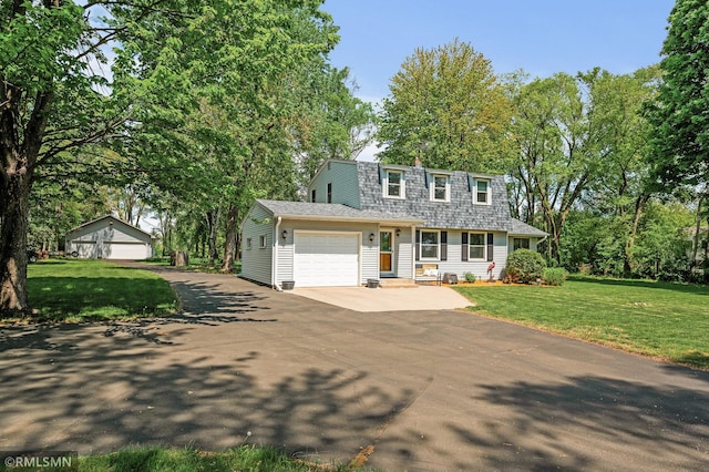 11228 10th St N, Lake Elmo, MN 55042 - front of property with asphalt driveway, a garage, a front yard, a gambrel roof, and roof with shingles