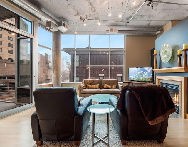 100 2nd St NE Unit A270, Minneapolis, MN 55413 - living room with wood finished floors, rail lighting, a glass covered fireplace, and expansive windows