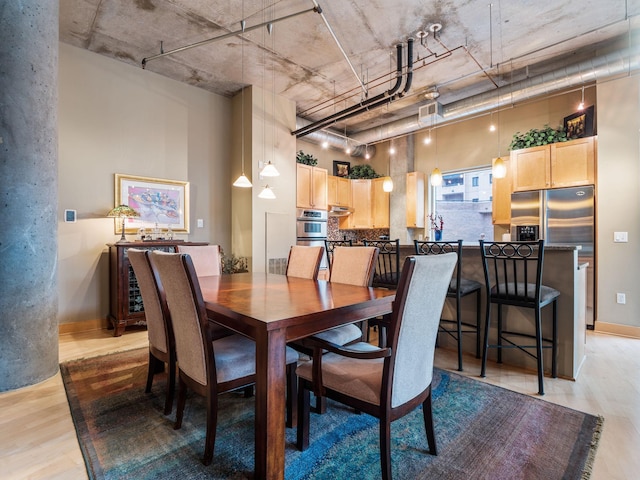 100 2nd St NE Unit A270, Minneapolis, MN 55413 - dining room with light wood-style flooring, baseboards, and a towering ceiling