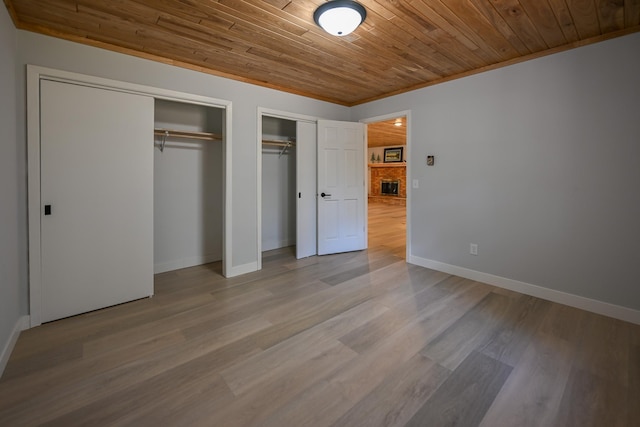 1192 Blackburn Rd, Scott Twp, WI 54801 - unfurnished bedroom with multiple closets, wood ceiling, baseboards, and wood finished floors