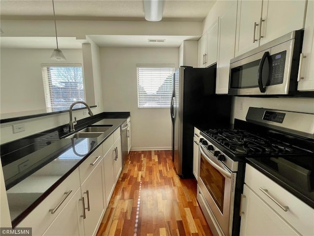 7601 Aldrich Ave S Unit 119, Richfield, MN 55423 - kitchen with appliances with stainless steel finishes, a sink, white cabinetry, and dark countertops