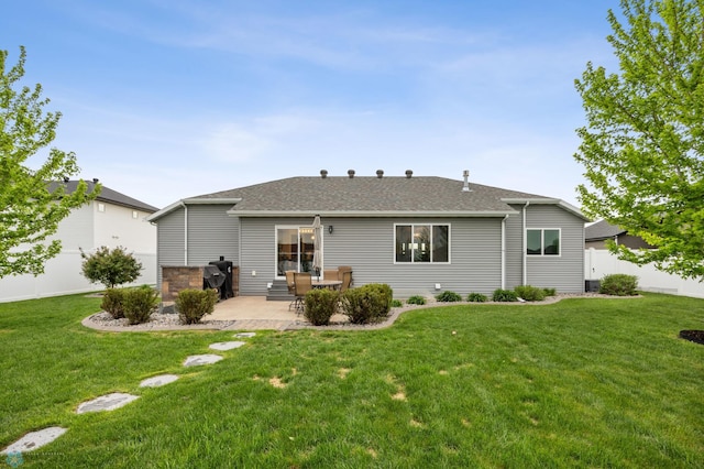 back of property featuring a patio area, a yard, and a shingled roof