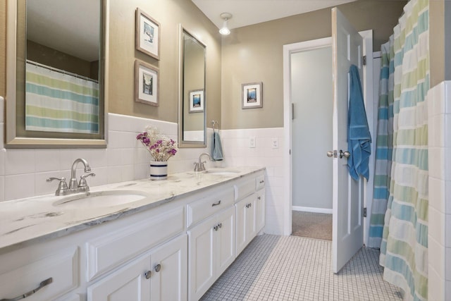 2241 17th St NW, New Brighton, MN 55112 - bathroom featuring double vanity, tile patterned floors, tile walls, and a wainscoted wall