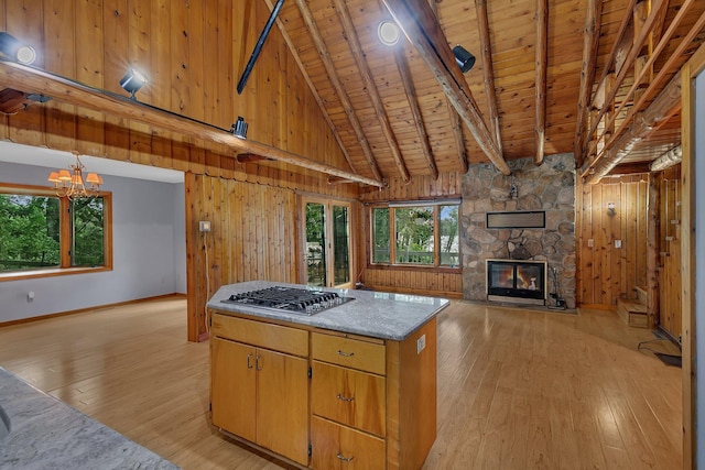 13047 Endicott Dr NW, Clearwater, MN 55320 - kitchen with light wood-style flooring, stainless steel gas stovetop, wooden ceiling, a kitchen island, and wood walls