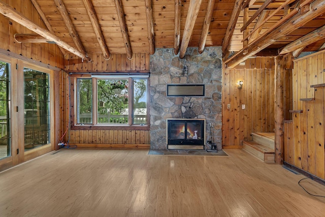 13047 Endicott Dr NW, Clearwater, MN 55320 - unfurnished living room with wood finished floors, a stone fireplace, wooden ceiling, wooden walls, and stairway