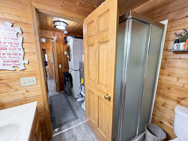 41443 County Highway 1, Ottertail, MN 56571 - full bathroom featuring estacked washer and dryer, wood walls, a stall shower, wooden ceiling, and wood finished floors