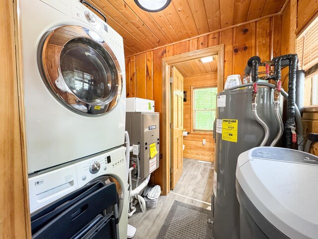 41443 County Highway 1, Ottertail, MN 56571 - clothes washing area with stacked washer / dryer, wooden ceiling, wooden walls, electric water heater, and light wood-style floors