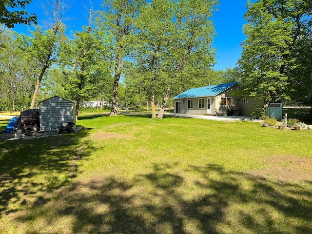 41443 County Highway 1, Ottertail, MN 56571 - view of grassy yard featuring a storage unit, an outdoor structure, and a patio