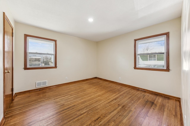 unfurnished room with hardwood / wood-style floors, plenty of natural light, baseboards, and recessed lighting