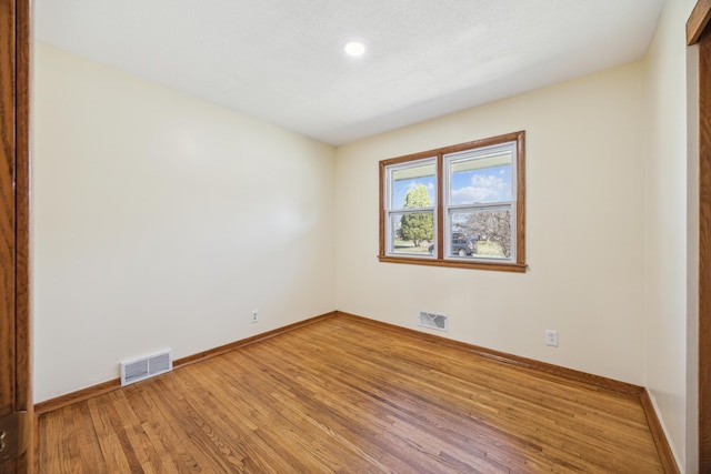 unfurnished room with wood finished floors, baseboards, and recessed lighting
