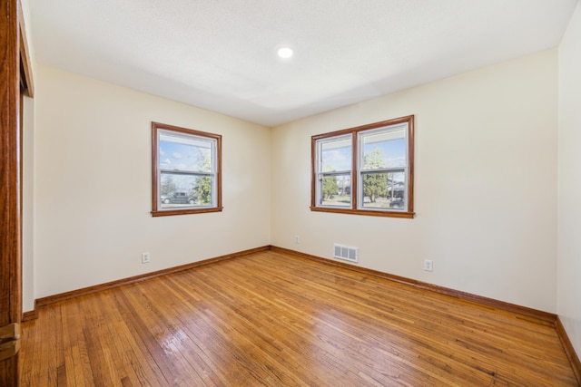 spare room with healthy amount of natural light, light wood-style floors, baseboards, and recessed lighting