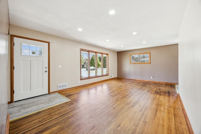 entryway with wood finished floors, baseboards, and recessed lighting