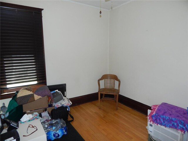 bedroom featuring ornamental molding, light wood-type flooring, and baseboards
